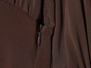 Nahaufnahme des hochwertigen unsichtbaren Reißverschlusses am braunen Kleid