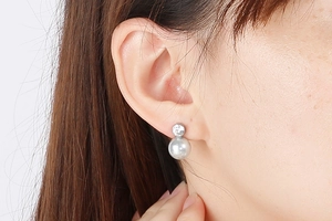Close-up of elegant grey pearl drop earrings with crystal studs worn by a model