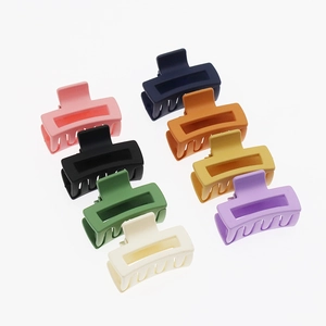 Macro view of eight matte hollow rectangular hair claws in various macaron colors