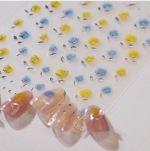 Détail de stickers à ongles roses avec bordure dorée et motifs floraux bicolores