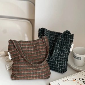 Close-up of retro plaid wool fabric texture and simple wish brand label on tote bags