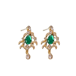 Vintage green teardrop earrings with crystals and gold-tone leaf design on white background