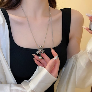Dettaglio della collana a catena serpente d'argento con ciondolo a croce di strass neri