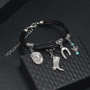 Detail of black leather multi-layer bracelet with cowboy charms and Good Luck horseshoe