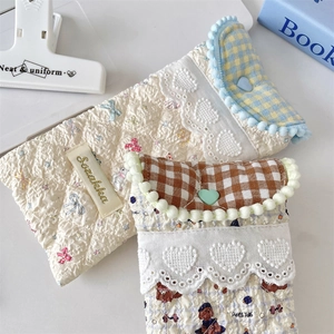 Detailed view of quilted cotton glasses pouch with lace trim and heart-shaped snap button