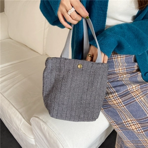 Small wool herringbone tote bag shown in a cozy lifestyle setting