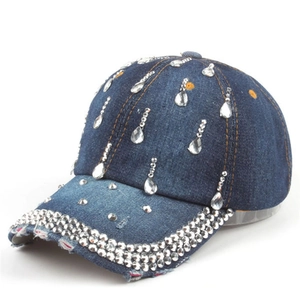 Dettaglio cappello da baseball in denim blu con strass a goccia e bordi sfilacciati