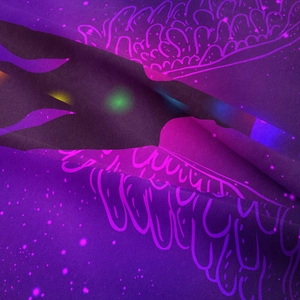 Close-up detail of high-precision printed purple psychedelic tapestry with neon patterns