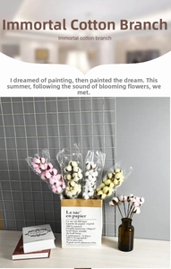 Close-up of dried cotton flowers in various colors like pink and cream in a brown glass vase