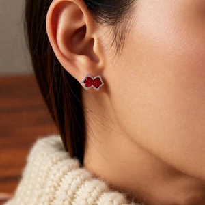 Macro shot of sparkling red gemstone bow ear clip with small white zircon pavé details