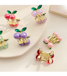 Macro detail of cherry-shaped hair clips with colorful resin beads and gold alloy frame