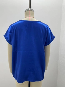 Back view of a glossy royal blue satin blouse on a mannequin with smooth fabric texture