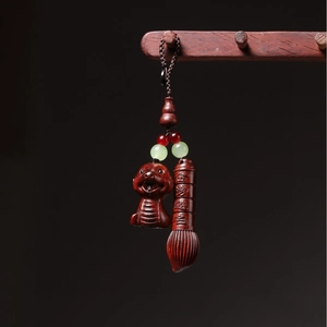 Detail of hand-carved wood dragon pendant and brush with cultural calligraphy art