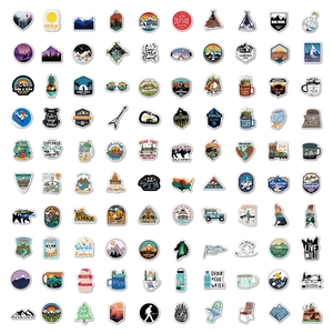 Flat lay of 100 waterproof PVC outdoor camping stickers with colorful adventure designs