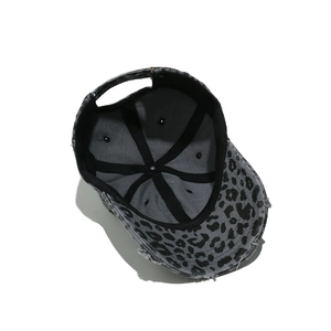 Detail view of leopard print baseball cap featuring distressed edges and metal buckle
