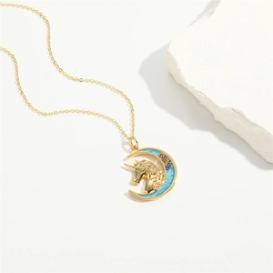 Exquisite gold unicorn crescent moon necklace with colorful stones on white stone base