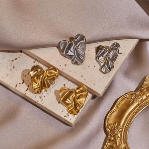 Macro di orecchini a cuore con trama in metallo stropicciato oro e argento lucido