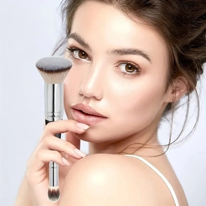 Detail of dual-ended makeup brush featuring black bristles and a sleek silver metal handle