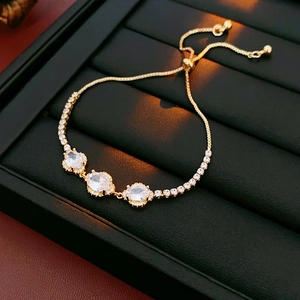 Detail of gold flower bracelet with oval zircons and adjustable pull-string clasp