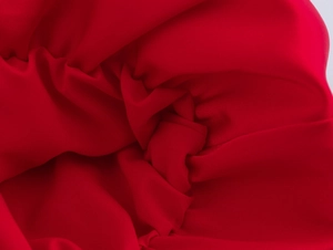 Gros plan sur la texture du tissu rouge lisse et les plis doux du short d'été doux