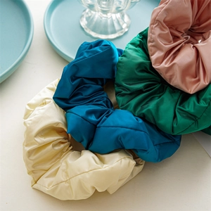 Satin fabric scrunchies in cream, navy, dark green, and pink colors for hair styling