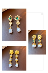 Detail of vintage gold plated drop earrings with pearls and emerald green gemstones