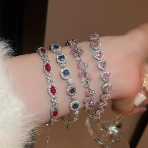 Detailed view of silver charm bracelets with colorful heart and square zircon pendants