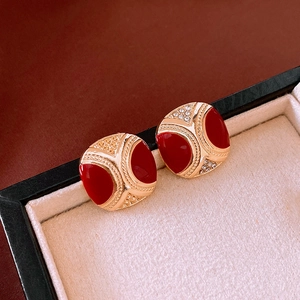 Detail of vintage square gold-toned earrings with red enamel and sparkling rhinestones