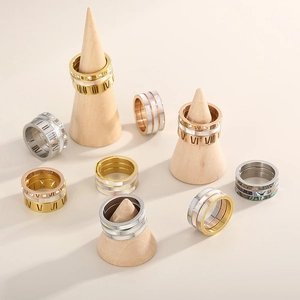 Detailed view of layered stainless steel rings with Roman numerals and shell inlays
