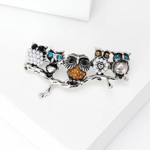 Detail of owl branch brooch with white pearls, blue and orange rhinestones on silver alloy