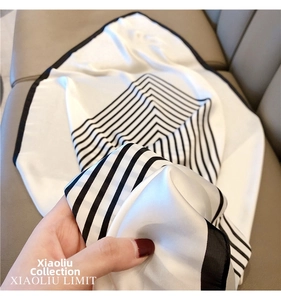 Close-up of a large black and white striped silk scarf with a glossy and smooth texture