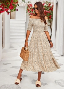 Schulterfreies Midikleid mit Blumenmuster und Smok-Oberteil in sommerlicher Umgebung