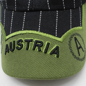 Close-up of Austria logo 3D embroidery on a striped black and green baseball cap