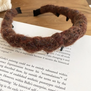 Detailed view of brown acrylic wool braided headband with internal teeth for secure fit