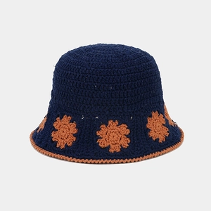 Detailed macro view of the intricate crochet floral pattern on a navy bucket hat