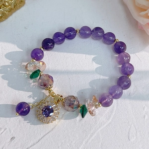 Detail of amethyst bracelet with sunflower pendant and cubic zirconia floral charms