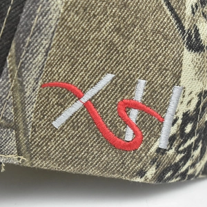 Detailed macro shot of 3D fish bone embroidery on a camo tactical baseball cap