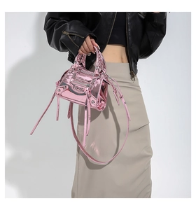 Detail view of pink patent leather handbag featuring rivets and long decorative tassels