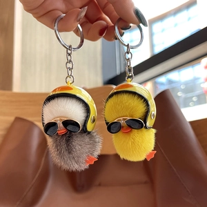 Detail of plush duck keychains in grey and yellow with mini helmets and sunglasses