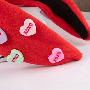 Detail of red plush headband featuring pastel heart buttons with XOXO lettering