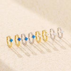 Detail of s925 silver ear hoops with blue and white opal inlays in gold and silver