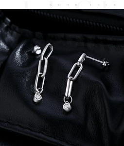 Macro shot of S925 silver geometric link earrings with sparkling round moissanite drops