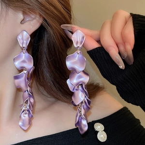 Close-up of long purple layered petal tassel earrings with a sleek satin metallic finish