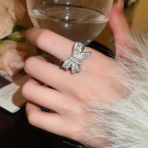 Close-up of elegant silver bow ring with shimmering cubic zirconia on woman hand