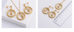 Detailed view of golden teardrop necklace and earrings with spiral twist texture