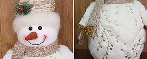 Detail of plush snowman doll featuring gold tree patterns and pine needle decorations