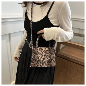 Detail of leopard print crossbody bag showing brown pattern and adjustable strap