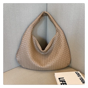Detailed view of the khaki woven leather texture on a stylish women tote bag