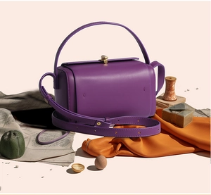 Détail du sac Boston cylindrique violet avec quincaillerie dorée et bandoulière amovible