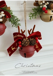 Close-up of red Christmas bell with reindeer antlers, pine cones and velvet bow ornament